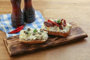 bruschetta with soft cheese capers and tomato photo