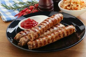 Grilled sausages with cabbage and sauce photo