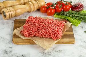 Raw minced beef meat on cutting board photo