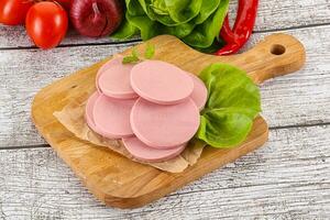 Slices boiled sausages for breakfast photo