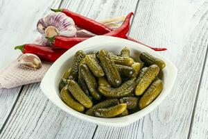 Marinated small cucumbers in the bowl photo