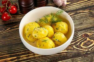 Boiled potato with oil and dill photo