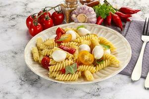 Italian pasta with mozzarella and tomato photo