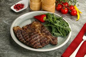 Grilled chuck roll steak with arugula photo