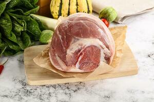 Uncooked raw pork knuckle with spices photo