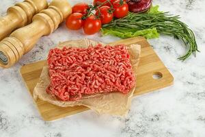 Raw minced beef meat on cutting board photo