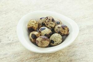 Raw quail eggs heap in the bowl photo