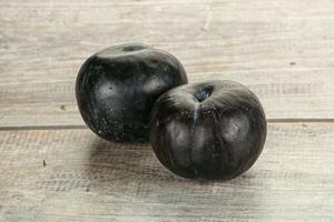 Two ripe sweet black plums photo