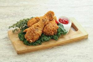 Fried chicken drumsticks with tomato sauce photo