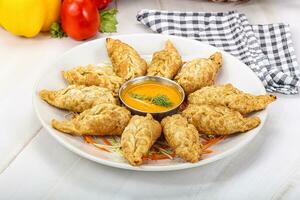 Fried stuffed momo dumplings with sauce photo