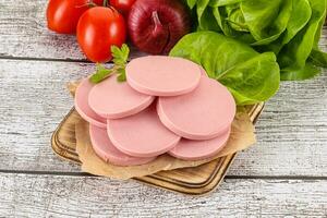 Slices boiled sausages for breakfast photo