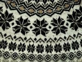 Black and white Winter Knitted Sweater Pattern Design with snowflakes. Handmade knitting wool fabric texture. Background of kniting patterns and ornament. photo