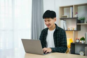 Smart Asian man with braces smiling working with computer laptop. concept work form home, stay at home. freelance life style, New normal social distancing lifestyle. Work form anywhere concept. photo