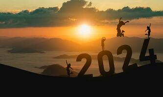 Woman jump happy new year 2024 concept, silhouette of woman jumping over barrier cliff and success with beautiful sunset background. Happy New Year 2023 use for web banner and advertisement. photo