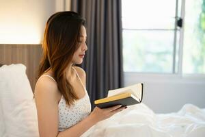 Asian woman doing hands together in prayer to God along with the bible In the Christian concept of faith, spirituality and religion, women pray in the Bible. prayer bible on the bed in the bedroom. photo