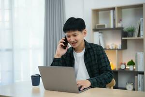 Freelance business man calling on mobile smartphone while working with laptop on table, businessman mobile phone to calling with customers or shopping online. Smart phone conversation conferrence. photo