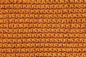 Orange knitted fabric texture background. Top view. Copy, empty space for text photo