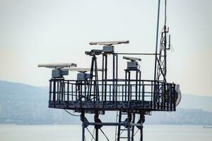 Rotating antennas of a military radio station on tower. photo