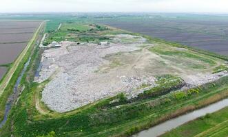 garbage dump with heaps of garbage and treatment facilities. Landfill of garbage outside the village photo