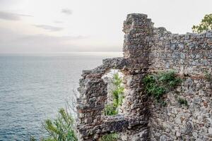 Ruins of ancient buildings on coast of Antalya. Ancient buildings by the sea. photo