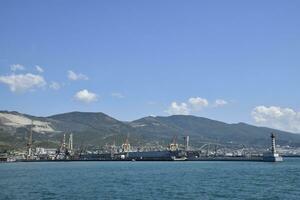 Cargo port with port cranes. Sea bay and mountainous coast. photo