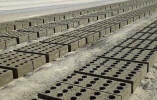 Cinder blocks lie on the ground and dried. on cinder block production plant. photo