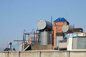 Steel barrels of boilers with water on the roof of a building to heat water photo