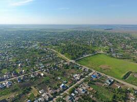 Top view of the village. One can see the roofs of the houses and gardens. Road and water in the village. Village bird's-eye view photo