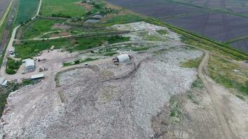 garbage dump with heaps of garbage and treatment facilities. Landfill of garbage outside the village photo