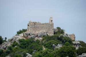 ruins of an ancient fortress on top of a cliff. Kekova Turkey city ruins. photo