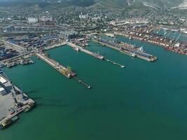 Industrial seaport, top view. Port cranes and cargo ships and barges. Loading and shipment of cargo at the port. View of the sea cargo port with a bird's eye view photo