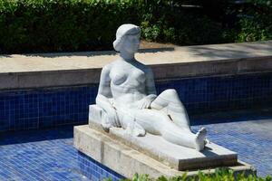 moderno mármol estatua, desnudo mujer estatua en fuente. foto