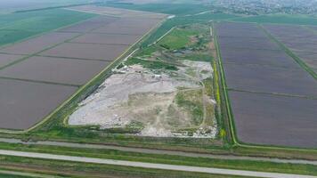 garbage dump with heaps of garbage and treatment facilities. Landfill of garbage outside the village photo