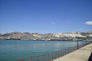 carga Puerto con Puerto grúas mar bahía y montañoso costa. foto