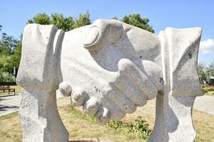 escultura apretón de manos. símbolo de amistad y cooperación foto