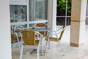 metal mesas y sillas con mimbre asientos en al aire libre cafetería. foto