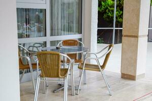 Metal tables and chairs with wicker seats in outdoor cafe. photo