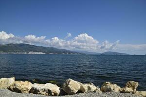 Sea bay landscape Tsemess. Mountains and clouds in the sky. In the distance can be seen the Marine cargo port photo