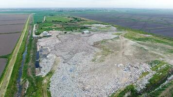 garbage dump with heaps of garbage and treatment facilities. Landfill of garbage outside the village photo