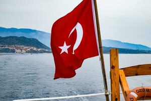 el bandera de Turquía revolotea en el viento en el cubierta de Placer yate. foto