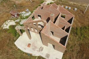 el casa es construido de rojo ladrillo. el paredes de el casa son un parte superior ver foto