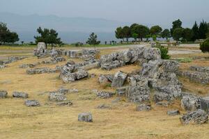 Fragments of ancient buildings, ruins of the ancient city of Hierapolis. Stone blocks with traces of stone machining. photo