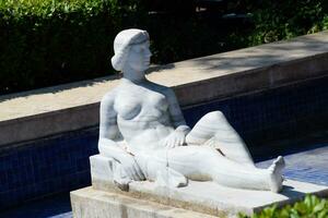 Modern marble statue, nude woman statue in fountain. photo