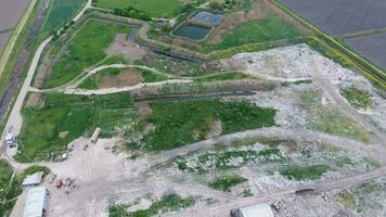 garbage dump with heaps of garbage and treatment facilities. Landfill of garbage outside the village photo