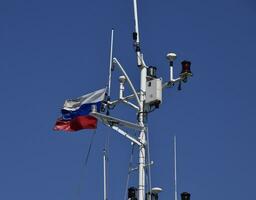 Mast of the port service ship. Devices of light signaling and communication antenna. photo