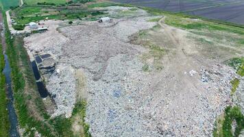 garbage dump with heaps of garbage and treatment facilities. Landfill of garbage outside the village photo