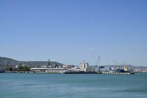 Cargo port with port cranes. Sea bay and mountainous coast. photo