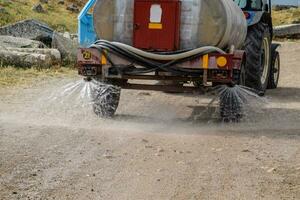 Machine for moistening dust on road. photo