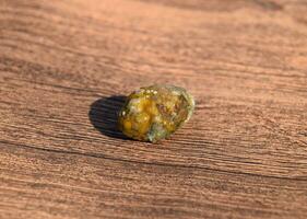 Stone of gallbladder. The result of gallstones. A calculus of dissimilar composition on a wooden background. photo