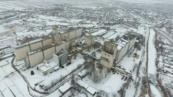 Grain terminal in the winter season. Snow-covered grain elevator in rural areas. A building for drying and storing grain. photo